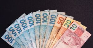 A imagem mostra várias notas de real para representar valores a receber do INSS