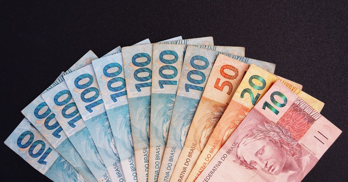 A imagem mostra várias notas de real para representar valores a receber do INSS