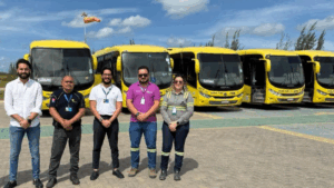 Equipe da Prime Plus com Cimento Apodi em frente à frota de ônibus utilizada no transporte de colaboradores em Quixeré.
