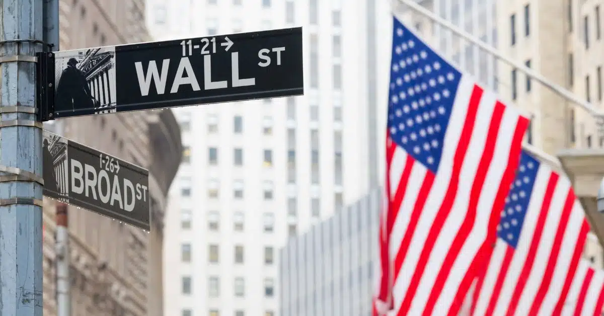 A imagem mostra uma placa escrita Wall Street para representar que a Wall Street sobe