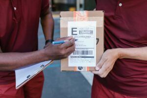 Pacote sendo entregue simboliza os gastos dos brasileiros com compras internacionais.
