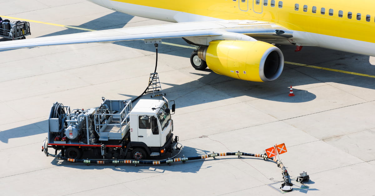A imagem mostra uma aeronave de médio porte sendo abastecida na pista do aeroporto, com equipamento e caminhão próprios para reabastecimento. A cena representa a transição tecnológica e logística necessária para o uso do combustível sustentável de aviação, previsto para ganhar escala a partir de 2027 no Brasil.