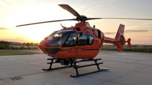 Helicóptero em operação ao pôr do sol, simbolizando a maior frota de helicópteros do mundo