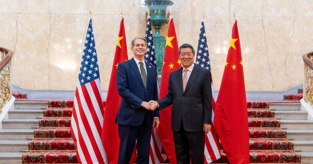 Autoridades dos EUA e da China apertando as mãos diante das bandeiras de seus países.