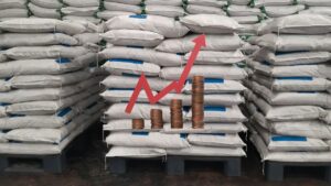 Sacos de fertilizante empilhados com gráfico de alta ilustrando o aumento no preço do fertilizante