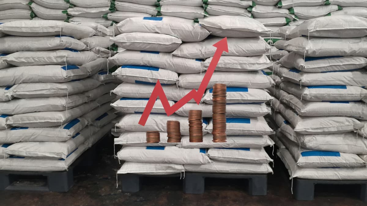Sacos de fertilizante empilhados com gráfico de alta ilustrando o aumento no preço do fertilizante