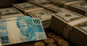 Notas de reais e dólares simbolizam quantos milionários existem no Brasil em 2025