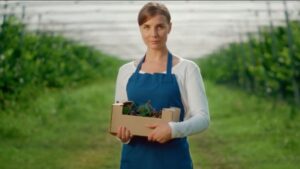 Produtora rural em plantação orgânica representando práticas de compliance ambiental no setor agroindustrial.