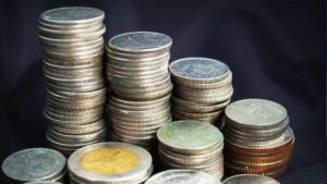 Dívida Pública Federal representada por pilhas de moedas brasileiras.