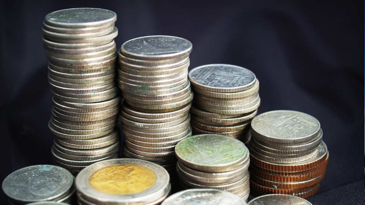 Dívida Pública Federal representada por pilhas de moedas brasileiras.