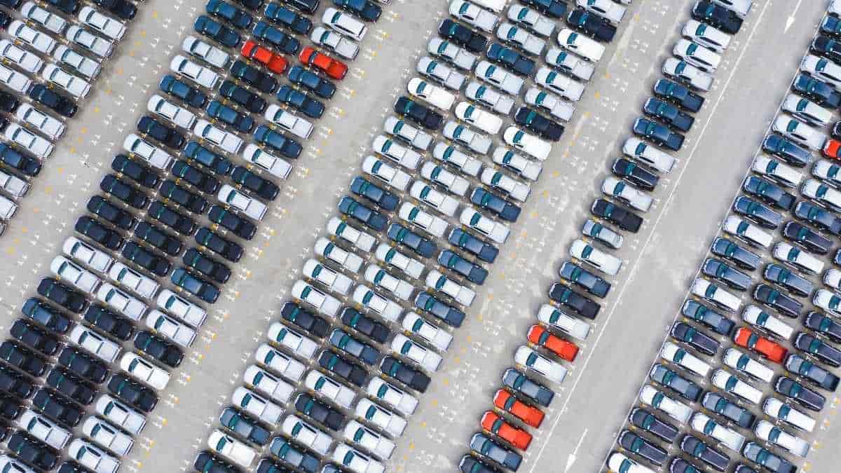 Imagem aérea mostra centenas de carros novos estacionados em pátio industrial, simbolizando o avanço das exportações de veículos no Brasil em 2025.
