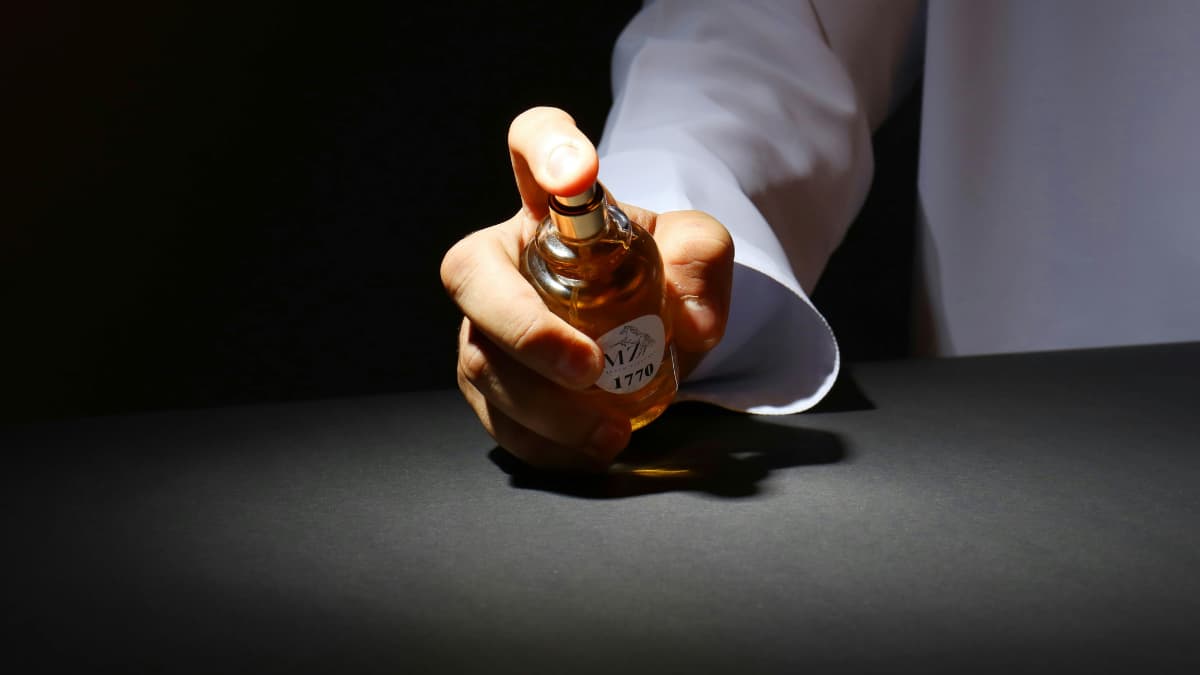 Pessoa borrifando perfume artesanal isento de registro na Anvisa