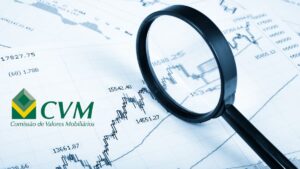 Gráfico financeiro sob lupa com logotipo da CVM, representando fiscalização sobre empresas inadimplentes na CVM.