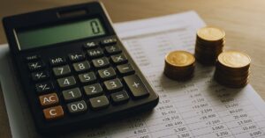Impacto da Selic na poupança com calculadora, extrato e moedas sobre mesa financeira
