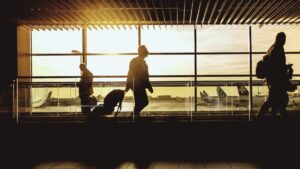movimentação de passageiros nos aeroportos durante o amanhecer, com viajantes circulando e aviões ao fundo