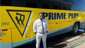João Paulo Fernandes em frente a ônibus do Grupo Prime Plus