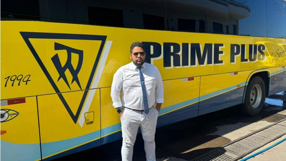 João Paulo Fernandes em frente a ônibus do Grupo Prime Plus