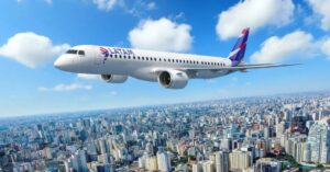 Avião Embraer Latam E195-E2 sobrevoa cidade com céu azul