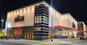 Fachada iluminada de uma unidade do Grupo São Luiz à noite.