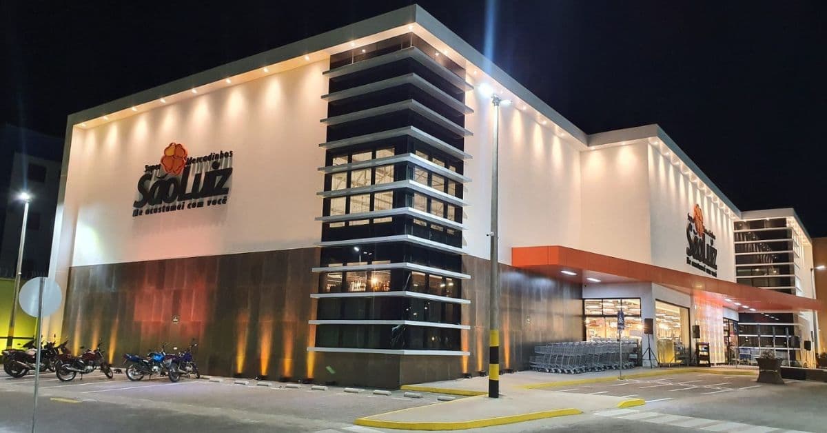 Fachada iluminada de uma unidade do Grupo São Luiz à noite.
