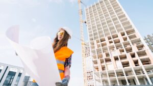 Engenheira observa projeto de construção em frente a edifício em obras, simbolizando o impacto do novo modelo de crédito imobiliário no setor habitacional.