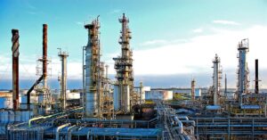 Refinaria de petróleo no Brasil com destaque para tanques e dutos — gasolina 10% mais cara pressiona política de preços da Petrobras.