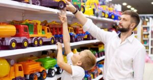 Pai e filho escolhem brinquedos no varejo durante as vendas do Dia das Crianças 2025