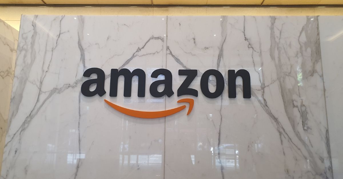 Logotipo da Amazon em parede de mármore, representando a entrada de grandes plataformas digitais no mercado financeiro brasileiro.
