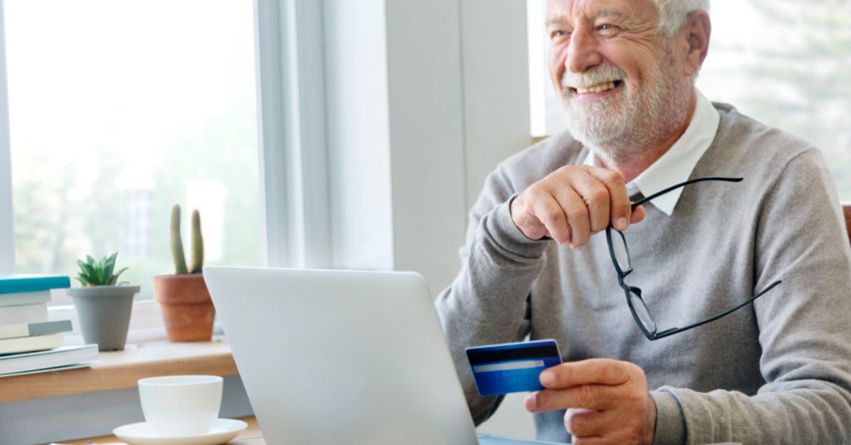 Idoso utilizando notebook para movimentações financeiras —economia da longevidade