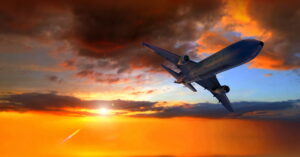 avião em voo durante o pôr do sol representa o financiamento para aviação verde aprovado pelo CMN