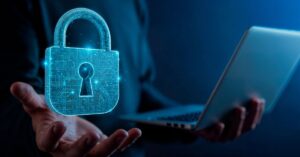 Profissional segura notebook com ícone digital de cadeado, simbolizando a proteção de dados e a segurança cibernética em fintechs.