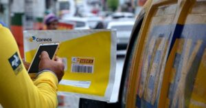 Funcionário dos Correios registrando encomenda, ilustrando o futuro dos Correios em meio à crise financeira.