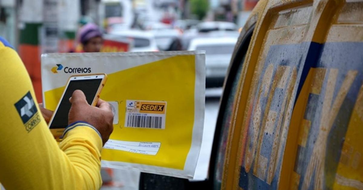 Funcionário dos Correios registrando encomenda, ilustrando o futuro dos Correios em meio à crise financeira.