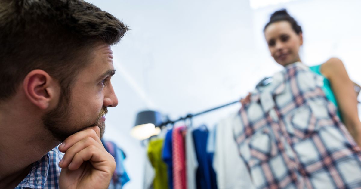 Consumidor analisando uma peça de roupa em cenário que reflete a Indecisão na Black Friday.