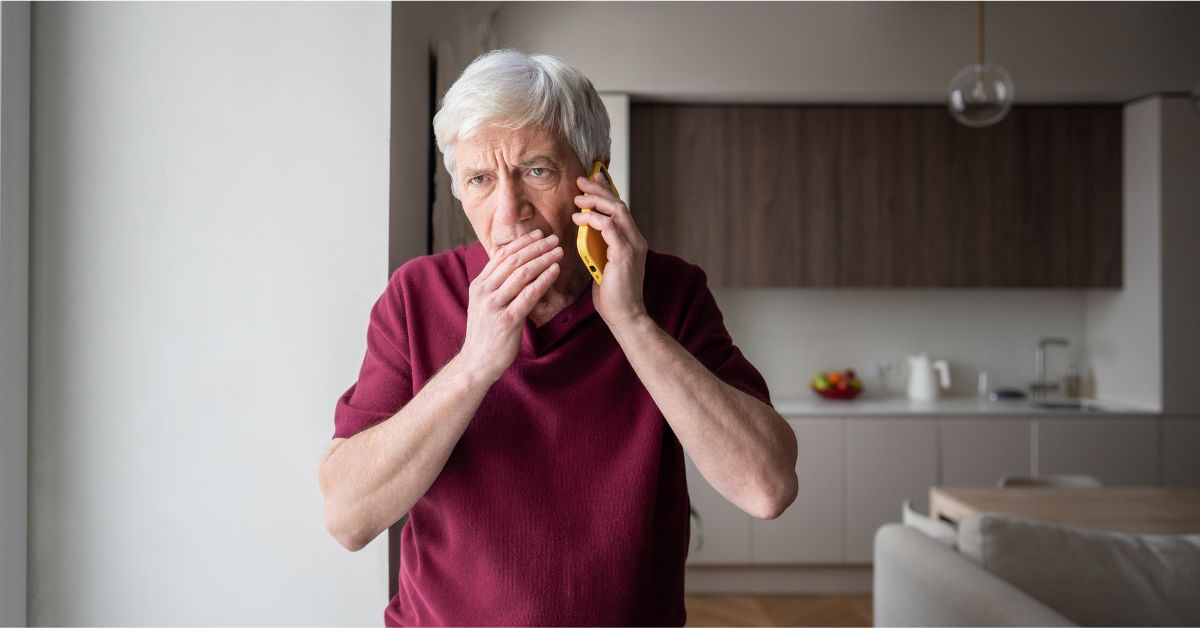 Idoso preocupado ao telefone, possível vítima de fraudes financeiras contra idosos