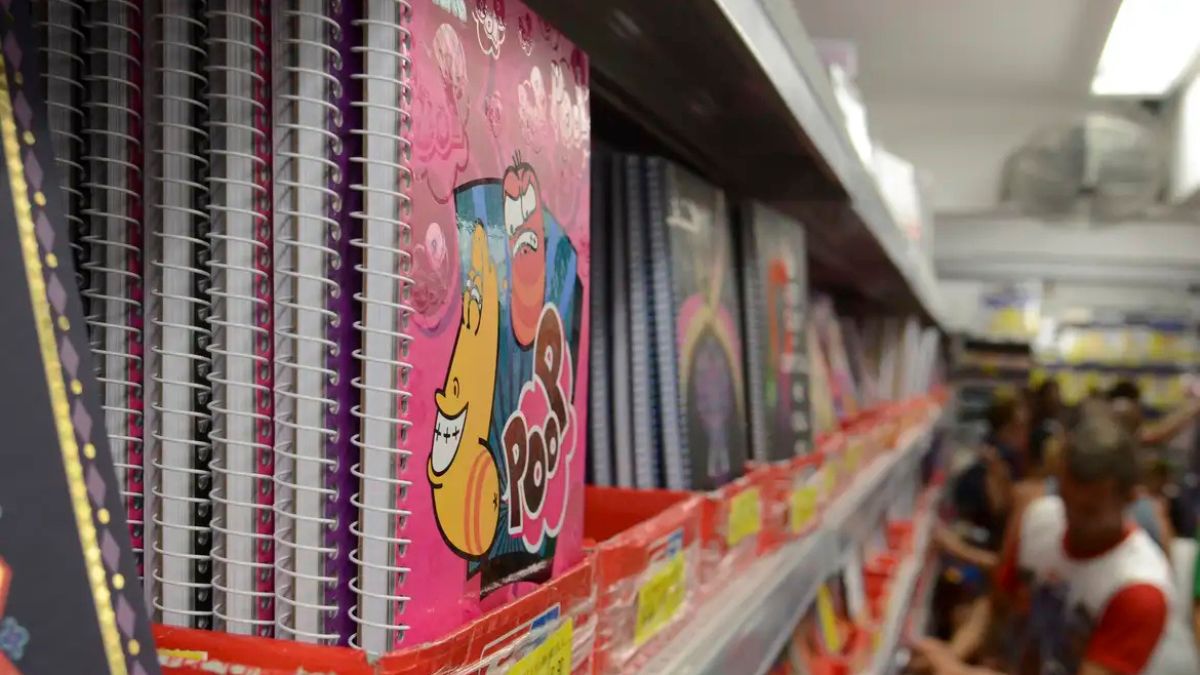Imagem de cadernos em uma livraria para ilustrar uma matéria jornalística sobre o custo do material escolar em 2026.