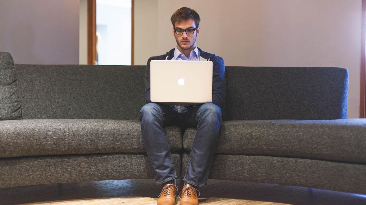 Imagem de um homem sentado fazendo um planejamento financeiro em um computador para ilustrar uma matéria jornalística sobre empreendedores milionários.