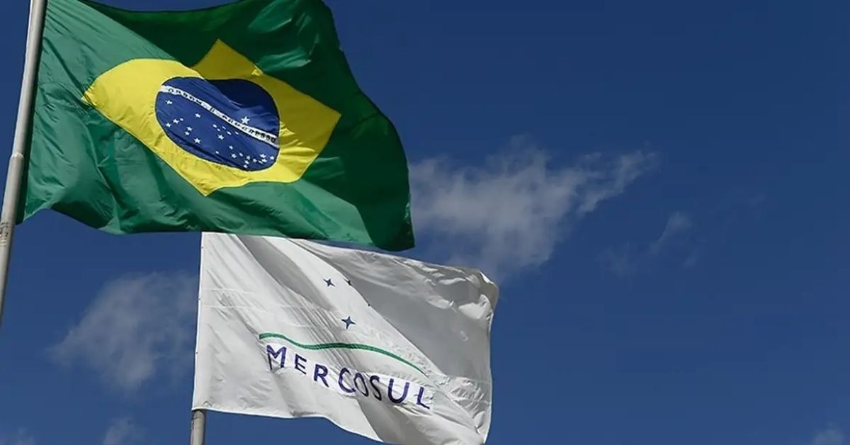 Bandeiras do Brasil e do Mercosul tremulando, representando a cooperação entre os países do Mercosul e a União Europeia no acordo comercial.