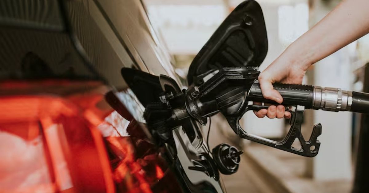 Pessoa abastecendo carro com etanol, combustível relacionado às exportações de etanol do Brasil.