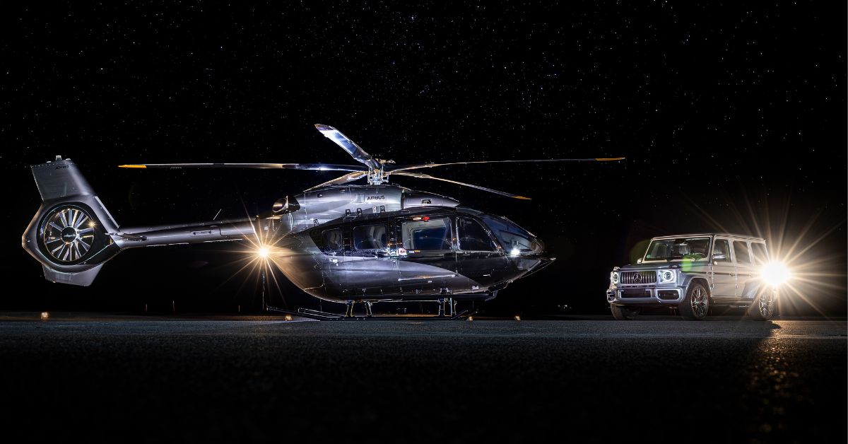 Airbus e Mercedes-Benz helicóptero ACH145 ao lado do SUV AMG G Class em pista noturna