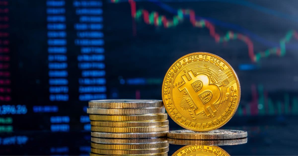 Representação física de criptomoedas na frente de gráficos representando imposto sobre criptomoedas e regulação no Brasil