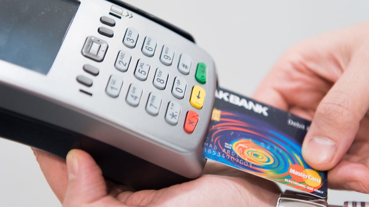 Imagem de um cartão de crédito e uma maquineta para ilustrar uma matéria jornalística sobre os Juros de cartão de crédito rotativo.