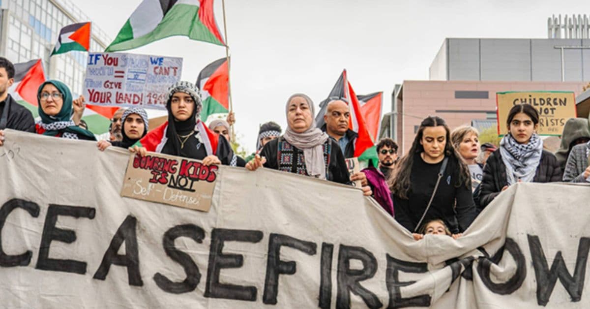 impacto econômico guerra Oriente Médio em protesto com bandeiras palestinas
