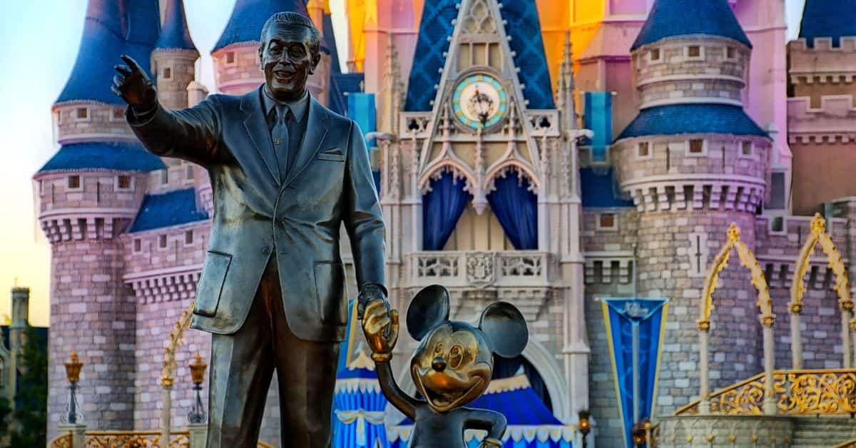 Estátua de Walt Disney e Mickey Mouse em frente ao castelo do parque da Disney