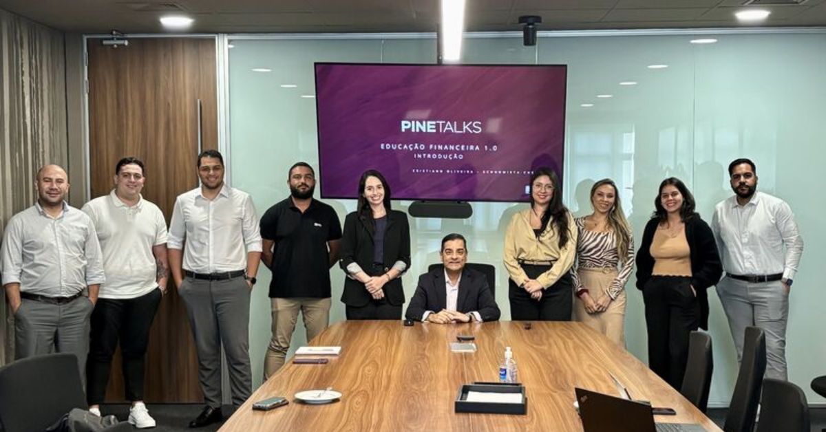 Cristiano Oliveira no centro com equipe do Banco Pine durante programa de educação financeira