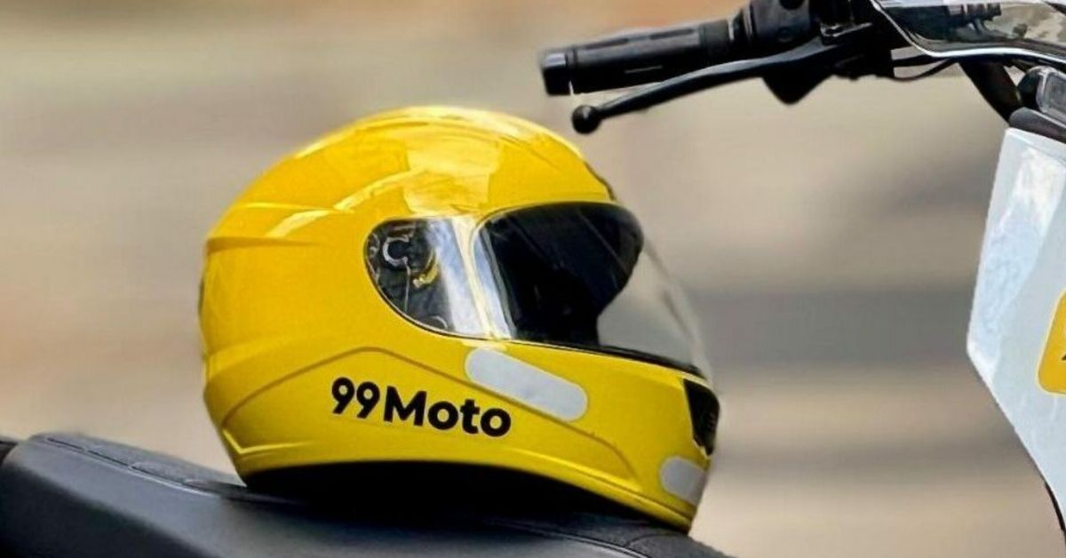 Capacete amarelo com logotipo 99Moto apoiado em motocicleta, representando serviço de mototáxi em São Paulo da 99