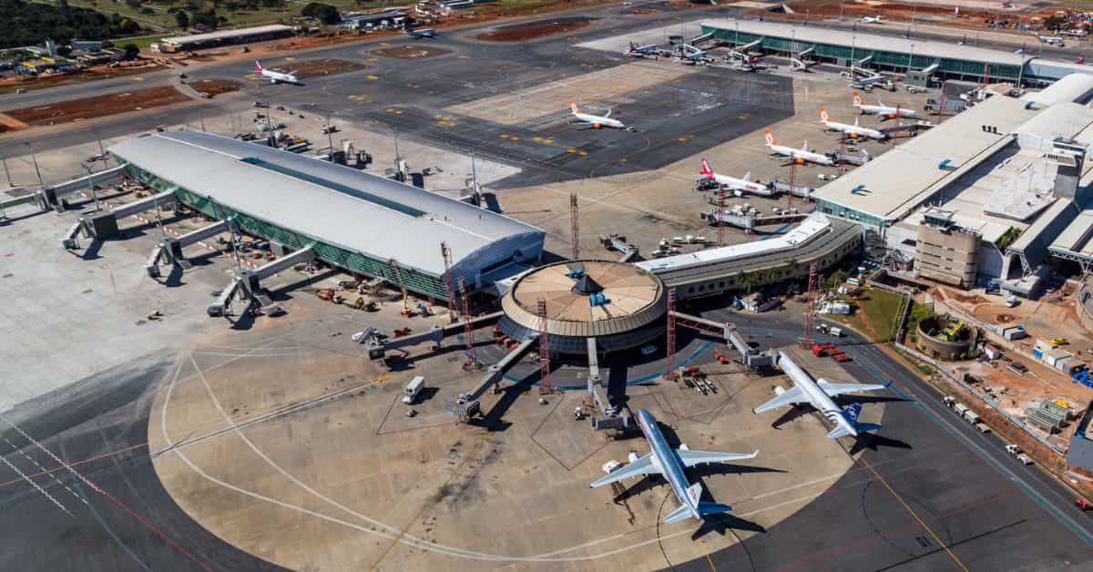 Aeroporto com aviões em solo e operações de embarque, cenário ligado à alta das passagens aéreas no Brasil