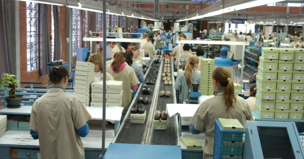 Funcionários trabalham em linha de produção de pequena indústria durante cenário de queda na confiança industrial