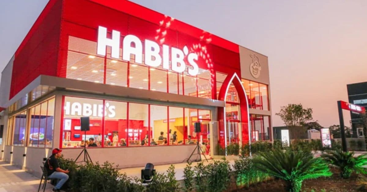 Fachada de unidade do Habib’s iluminada à noite, exemplo de franquia brasileira no exterior