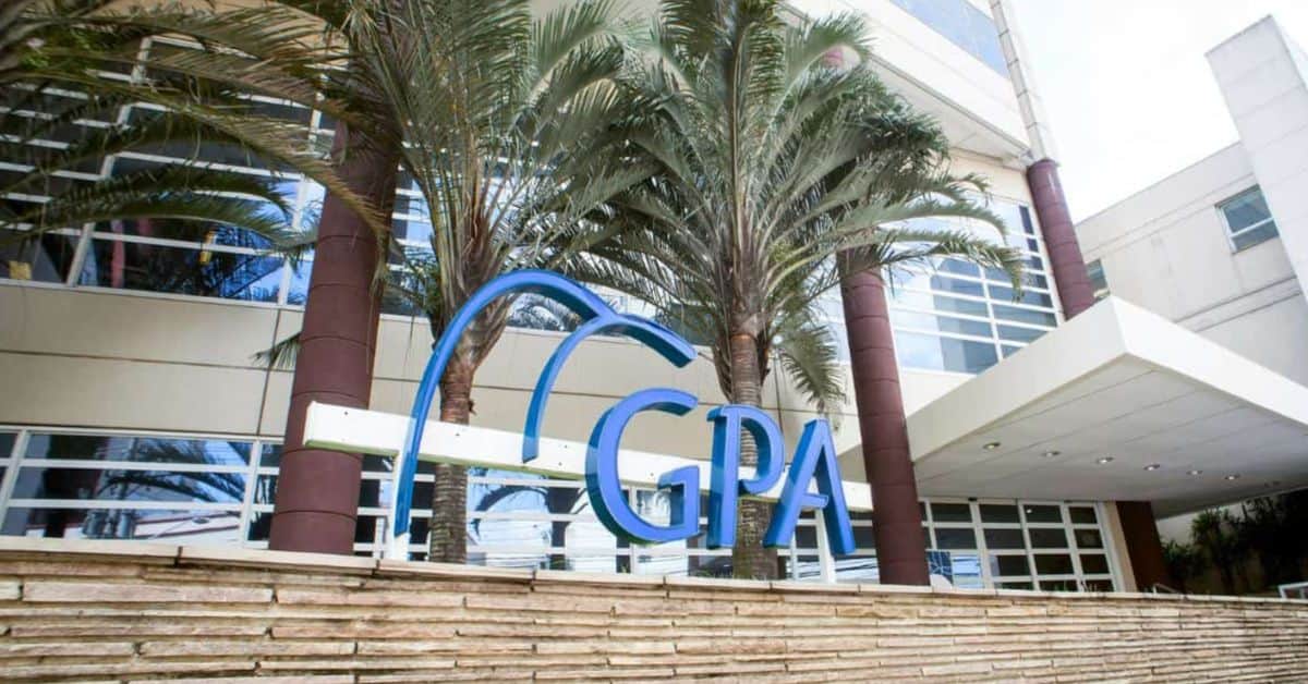 Fachada de prédio corporativo do GPA com logotipo azul da companhia em área externa cercada por palmeiras.